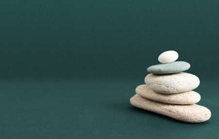 Zen stone pyramid isolated on green background with copy spaceの写真素材