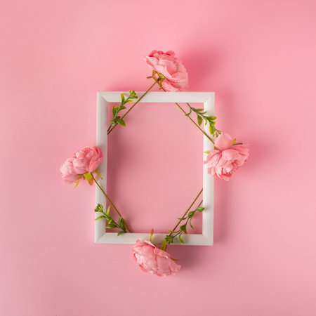White wooden frame with floral decoration top view on gentle pink background. Valentine day mockup layout with copy spaceの写真素材
