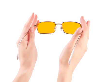 beautiful female hand with yellow driving glasses isolated on white with clipping pathの写真素材