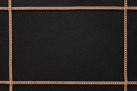 Black felt textured background with golden chain frameの写真素材