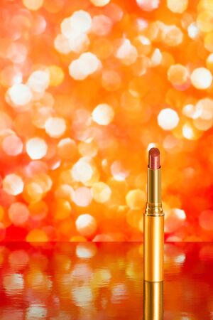 Red lipstick on red blurred background with reflection. Copy space includedの写真素材