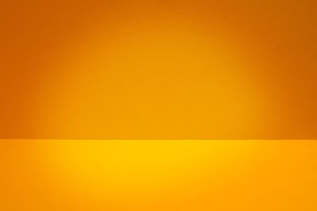 Clear empty yellow space. Wall and floor with light spot. Interior backgroundの写真素材