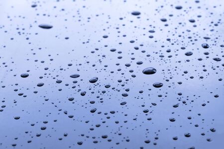 Blue surface with water drops. Focus on foreground, abstract texture and backgroundの写真素材