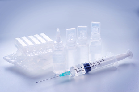 Group of plastic ampules and syringe. Health, treatment and modern medical science theme, toned imageの写真素材