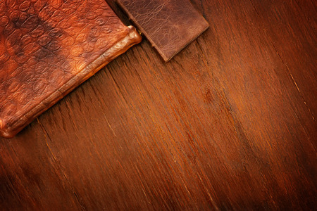 Leather covered books on old rough wooden table. Background and templateの写真素材