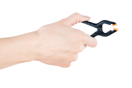 Woman hand holding black open clamp. Isolated on white, clipping path includedの写真素材