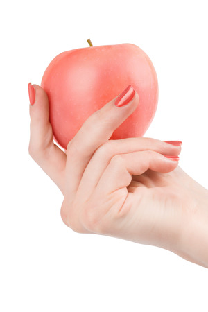 Woman hand with red nail polish holding bright pink apple. Isolated on whiteの写真素材