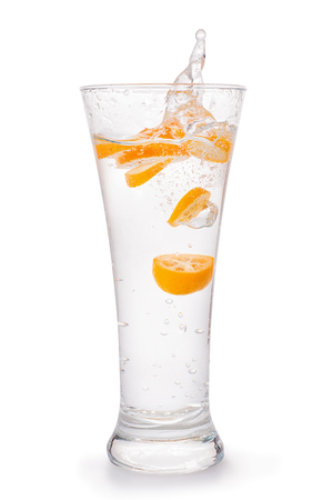 Glass of sparkling water with orange citrus fruit slices and water splash.の写真素材