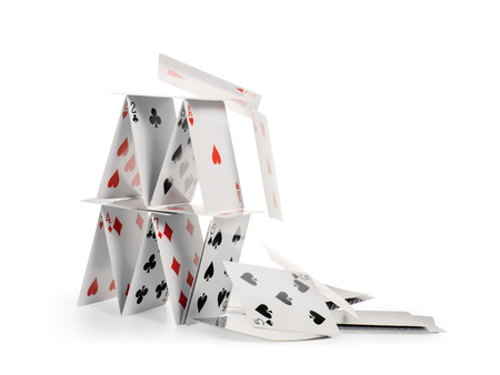 Crashed house of cards. Falling cards isolated on white, clipping path includedの写真素材
