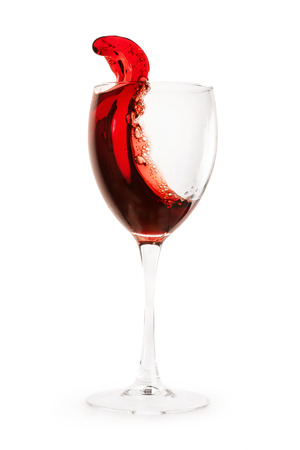 Red wine splash into drinking glass. Isolated on white, clipping path includedの写真素材