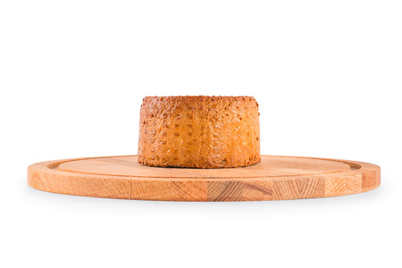 Round smoked cheese on the cutting board. Side view isolated on white, clipping path includedの写真素材