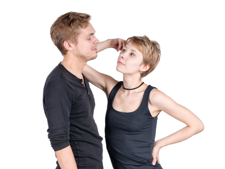 Modern sportive looking couple. Girl leaning on her boyfriend and looking defiantly at him. Isolated on whiteの写真素材