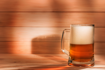 Beer pint on wooden background with copy space. Amber toned imageの写真素材