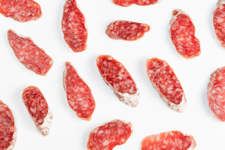 Smoked sausage slices top view on white backgroundの写真素材