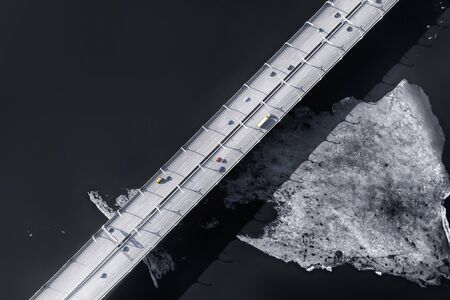 Elevated road over cold sea with ice aerial view. Dark toned imageの写真素材