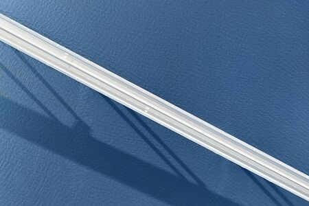 Long empty  bridge over large river or sea aerial top view with long shadowの写真素材