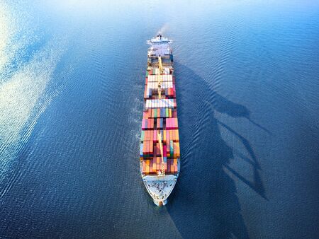 Large full loaded container ship sailing high seas. Aerial front view, hdr image