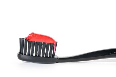 Black toothbrush with red toothpaste close up, Isolated on white backgroundの写真素材