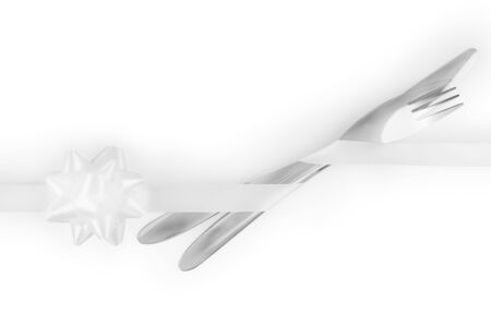 Fork and knife tied with a white ribbon with tied bow isolated on white, clipping path included