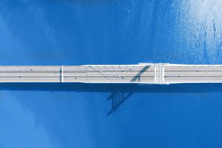 Long bridge over large river or sea aerial top view with long shadow