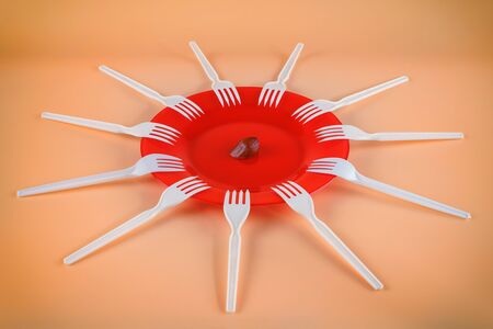 One sausage piece and lot of forks. Sharing, limited resources, shortage and contention concept. On...