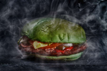 Green burger on the wooden background with smoke. Selective focusの写真素材