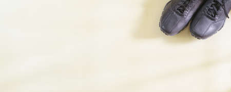 Pair of black shoes top view on long panoramic beige background. Abstract template with copy spaceの写真素材