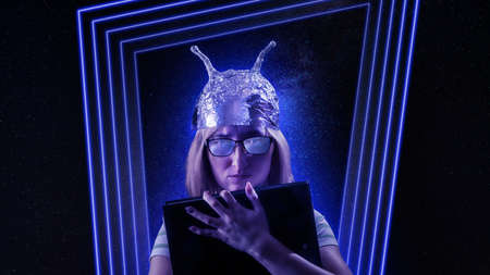 Girl in a foil hat against fantastic space theme background. Ð¡onspiracy theories, fantasy and mysticism theme imageの写真素材