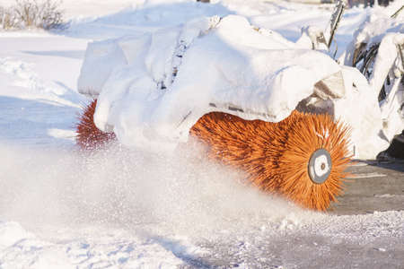 Rotating brush of a snowblower at work close up. Ð¡leaning snow in the city on a winter dayの写真素材