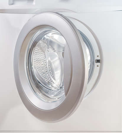 Open door of a washing machine close up with empty illuminated drumの写真素材