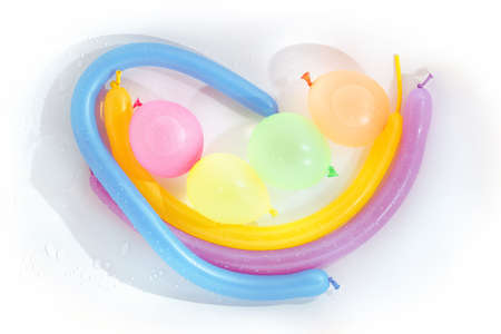 Wet rainbow colored balloons on white background. Abstract still lifeの写真素材