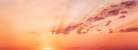 Awe sunset with sun rays and dramatic clouds. Panoramic orange colored scene, wide angle viewの写真素材