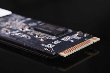 SSD M2 disk close up with selective focus on the interface. On dark background with reflectionの写真素材