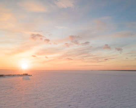 Ice on the frozen sea and bright colored sky at sunset. Aerial panoramic view, square compositionの写真素材