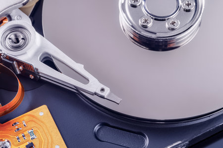 Disassembled hard drive close up with plates and head unit visible. Focus on the head unitの写真素材