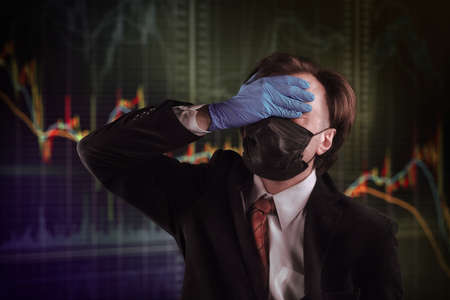 Businessman in formal suit, medical mask and gloves, makes facepalm. Crisis, epidemic, bad luck and accident themeの写真素材