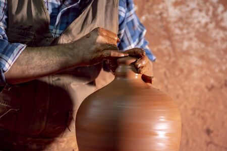 Professional potter making bowl in pottery workshop, studio.の写真素材