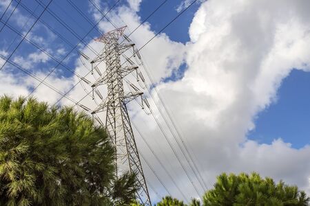 Electric pole, power plant with clouds in blue sky