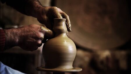 Professional potter making bowl in pottery workshop, studio.の写真素材