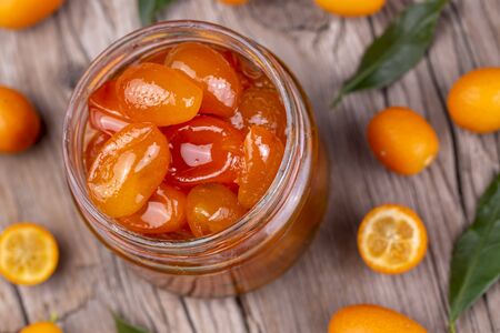 Homemade kumquat jam in jar and fresh kumquats, top viewの写真素材