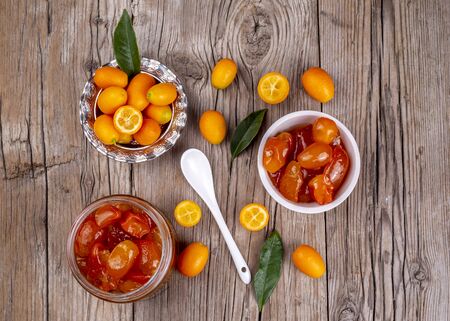 Homemade kumquat jam in jar and fresh kumquats, top viewの写真素材