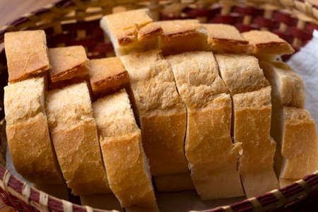 Sliced round loaf of rye bread with an appetizing crispy brown crust on a gray linen tablecloth.
