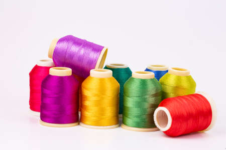 Colored thread coils on white background, sewing, place for text