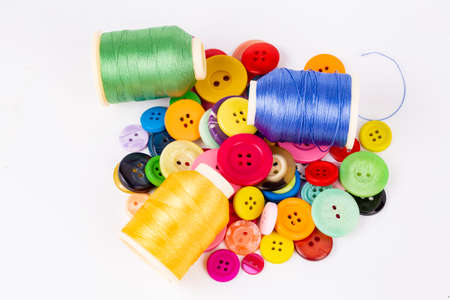 Colored thread coils on white background, sewing, place for text