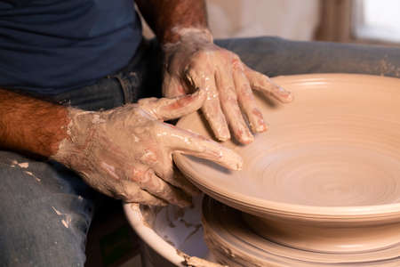 Professional potter making bowl in pottery workshop