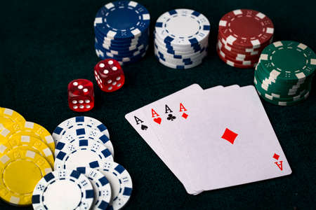 Ace playing cards with red dice. Casino betting and gambling concept and poker chips.