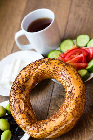 Turkish traditional breakfast with feta cheese, vegetables, olives, simit bagel and tea. Top view