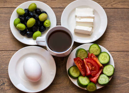 Turkish traditional breakfast with feta cheese, vegetables, olives, simit bagel and tea. Top view