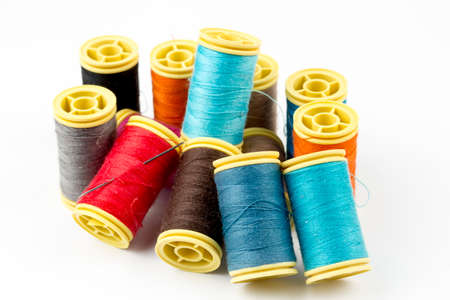 Colored thread coils on white background, sewing.