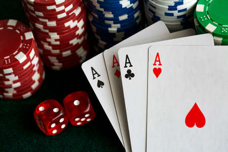 poker chips stack with two cards an ACE. On the green table on a black, dark background.